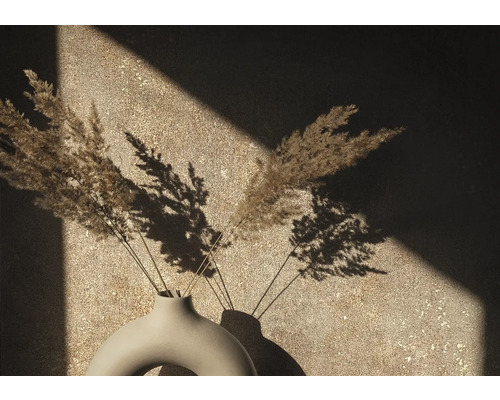 Dekoratívna váza so sušenými trávami pred stenou