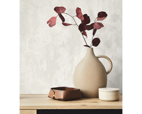 Dekoratívne aranžmán s vázou, vetvami a úložnými boxami na stole.