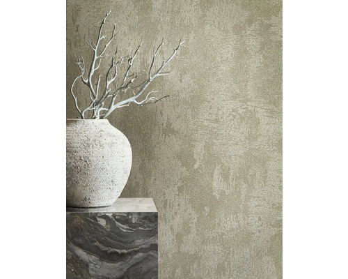 Detail nástennej tapety s reliéfnou textúrou vedľa ozdobnej vázy a vetiev