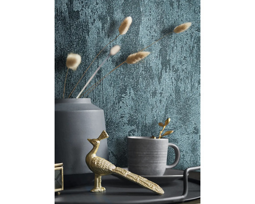 Dekoratívne zátišie s tapetou, zlatou figúrkou páva, šálkou a vázou