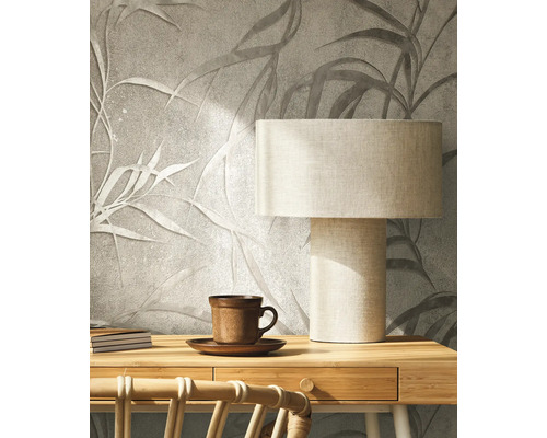 Dekoratívna stena s motívom listov, stolná lampa a šálka čaju pre útulnú atmosféru