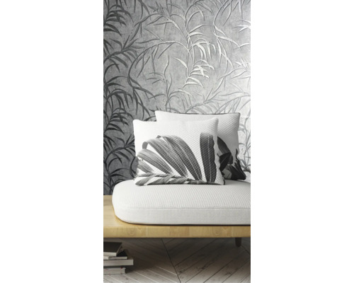 Dekoratívna obývacia izba so vzorovanou tapetou a vankúšmi s rastlinnými motívmi na pohovke