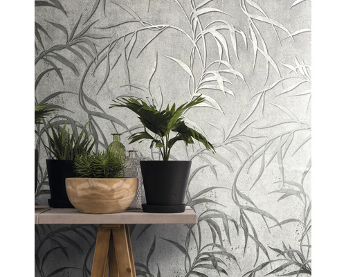 Nástenná dekorácia so sivou tapetou s listami a rastlinami na stole