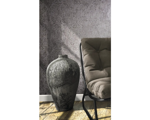 Dekoratívna váza vedľa stoličky pred vzorovanou tapetou