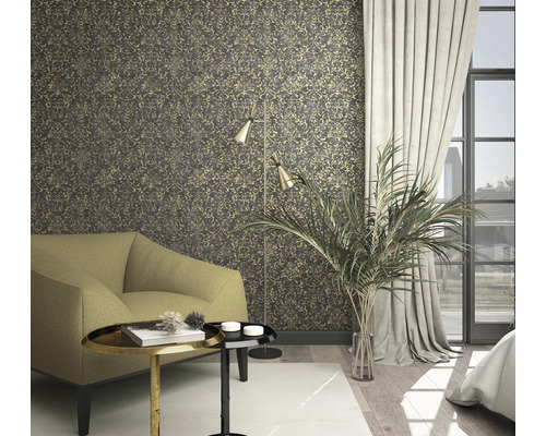 Obývacia izba so vzorovanou tapetou, kreslom, stojacou lampou a izbovou rastlinou