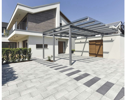 Exteriér obytného domu s terasou, dlažobnými kockami a prístreškom pre auto