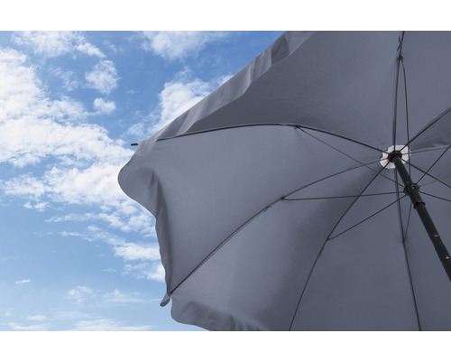 Otvorený slnečník na pozadí modrej oblohy s mrakmi