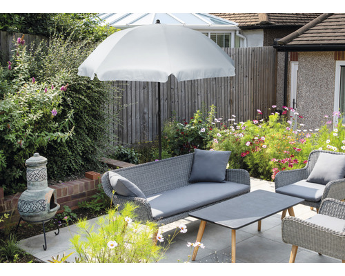 Záhradný nábytok so slnečníkom, pohovkou, kreslami a stolom na terase.