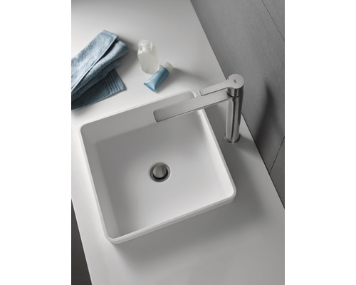 Na umývadle je umývadlová misa s batériou, uterák a toaletné potreby