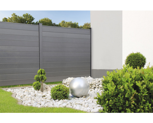 Záhradný pohľad s plotom, okrasným štrkom a dekoračnou guľou