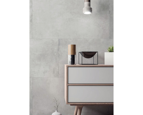 Moderný interiér so sivými obkladačkami, komodou a dekoráciami.