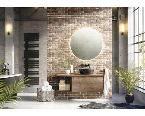 Kúpeľňa s umývadlom, zrkadlom, ohrievačom uterákov a dekoráciou pred tehlovou stenou