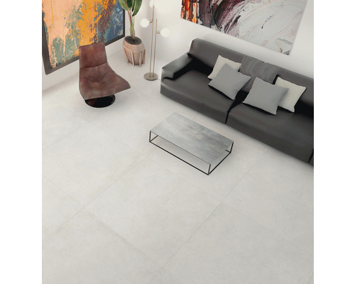 Svetlá obývacia izba s podlahovými dlaždicami, pohovkou a kreslom