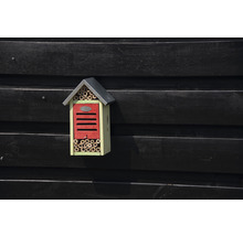 Hmyzí hotel s bambusovými rúrkami a strechou na drevenej stene