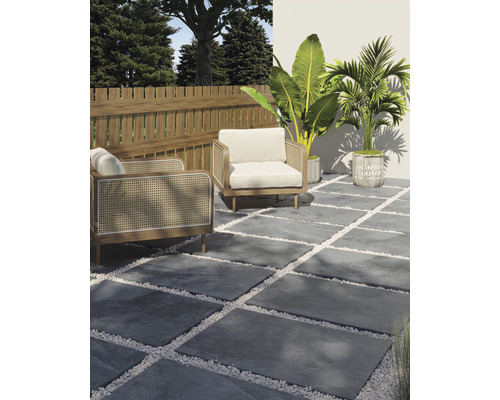 Terasa so sivými kamennými doskami, bielymi okrasnými okruhliakmi, dvoma kreslami, dreveným plotom a rastlinami