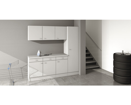 Práčovňa s bielymi skriňami, žehličkou, sušiakom na bielizeň a hromadou pneumatík