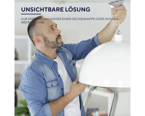 Muž montuje lampu na strop.