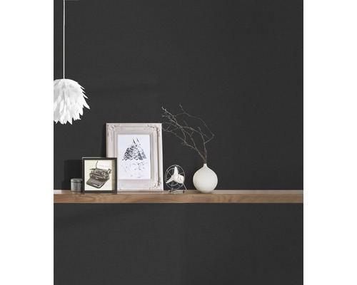 Dekoratívne predmety na drevenej polici pred tmavou stenou