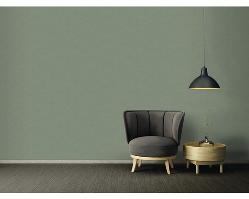 Príklad usporiadania s kreslom, odkladacím stolíkom a závesným svietidlom pred zelenou stenou
