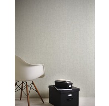 Interiérová scéna so svetlou tapetou, bielou stoličkou a čiernymi úložnými boxmi