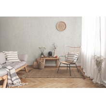 Obývacia izba s pohovkou, stoličkou a kobercom na parketovej podlahe pred štruktúrovanou stenou