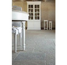 Interiér s kamennou dlažbou, bielym stolom a vitrínou