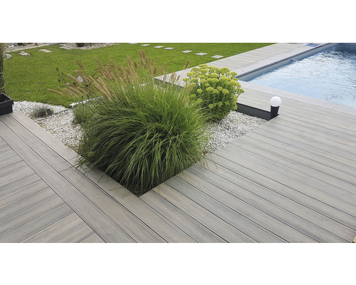 Terasa s drevenými doskami, rastlinami a bazénom v záhrade