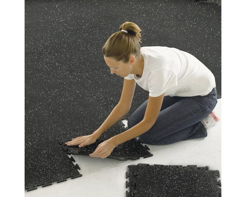 Žena kladie kompozitné dlaždice v interiéri