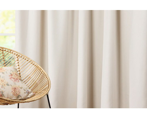 Dekoratívne látkové šály pred oknom s ratanovým kreslom