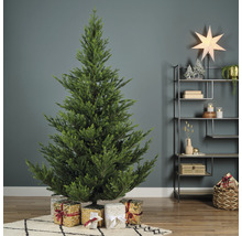 Zdobený umelý vianočný stromček s darčekmi v obývacej izbe.