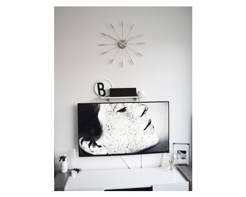 Obývacia izba s televízorom, hodinami a dekoráciami