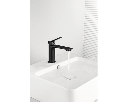 Čierna umývadlová batéria s tečúcou vodou v umývadle.