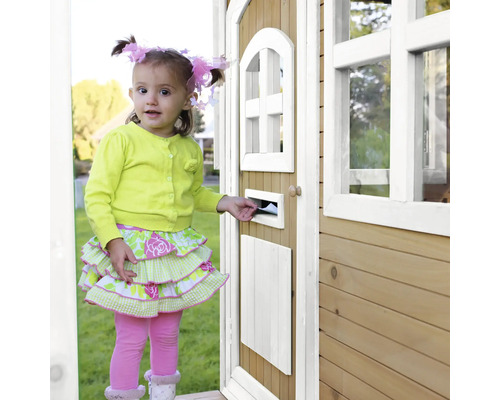 Dievča vkladá list do poštovej schránky dreveného domčeka na hranie