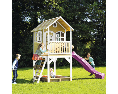 Detský domček so šmýkačkou a pieskoviskom v záhrade s hrajúcimi sa deťmi.