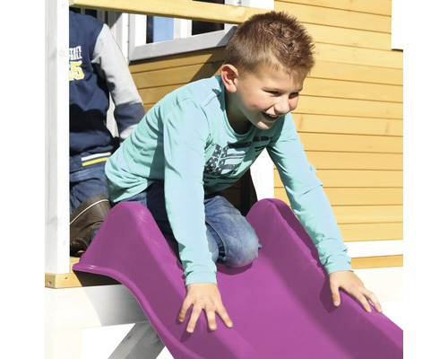 Chlapec sa šmýka na plastovej šmýkačke detského ihriska.