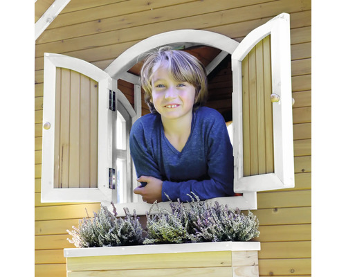 Dieťa vykúka z okna dreveného domčeka na hranie s okenným kvetináčom