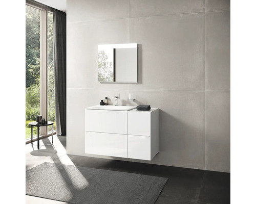 Kúpeľňa s bielou skrinkou pod umývadlo, zrkadlom a veľkoformátovými dlaždicami.