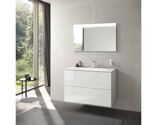 Moderná kúpeľňa s bielou skrinkou pod umývadlo, zrkadlom s osvetlením a oknom s výhľadom do zelene