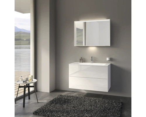 Moderná kúpeľňa s bielou umývadlovou skrinkou, zrkadlom s osvetlením a sivým kobercom.