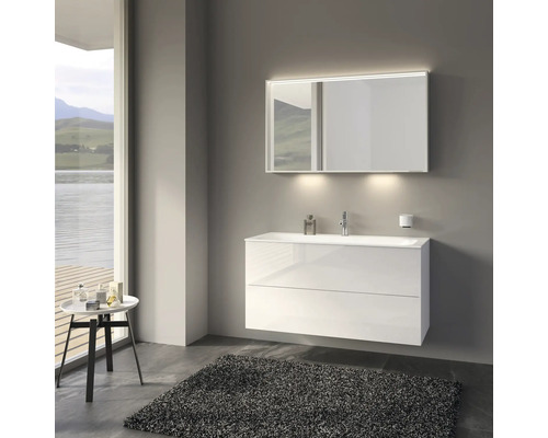 Kúpeľňa s bielou skrinkou pod umývadlo, osvetleným zrkadlom a kobercom