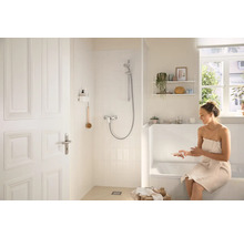 Svetlá kúpeľňa so sprchou, vaňou a ženou s uterákom