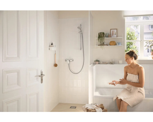 Svetlá kúpeľňa so sprchou, vaňou a ženou s uterákom