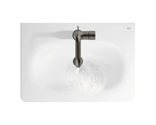 Pohľad zhora na umývadlo s batériou a tečúcou vodou