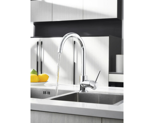 Chrómová kuchynská batéria s tečúcou vodou v umývadle