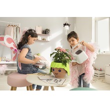 Dve dievčatá sa hrajú v izbe s rastlinou v kvetináči s tvárou a kanvou.