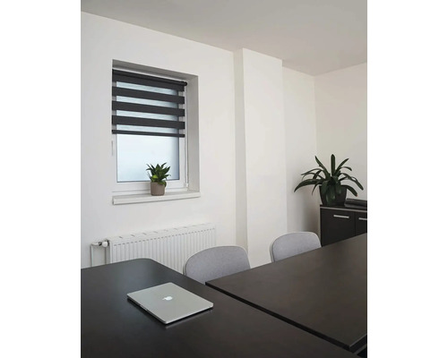 Interiér s oknom, roletou, stolom a kancelárskymi rastlinami