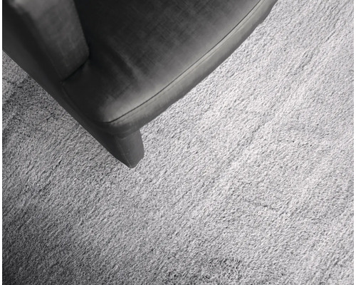 Detail svetlého koberca vedľa kusu nábytku