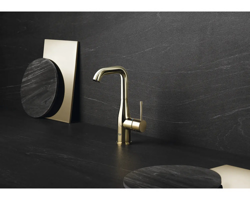 Zlatá kuchynská batéria na tmavom pozadí