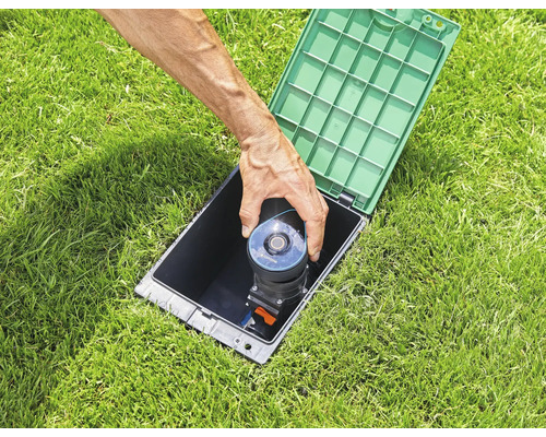 Zasúvací zavlažovač sa vkladá do čiernej skrine na trávniku