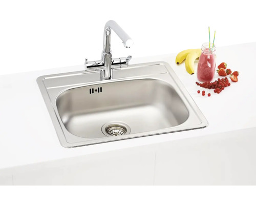 Nerezový drez s batériou na kuchynskej doske.